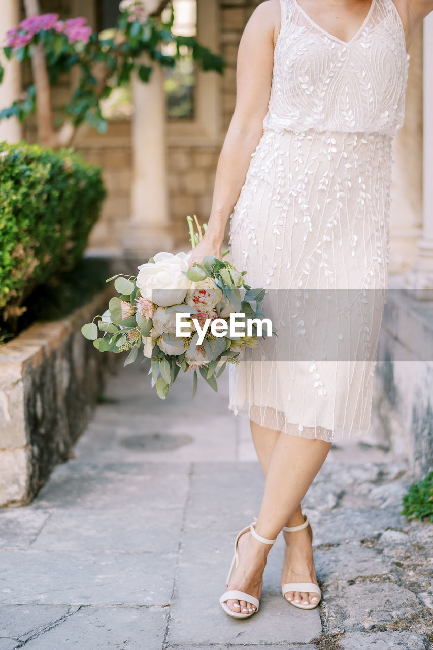 low section of woman standing by flowers