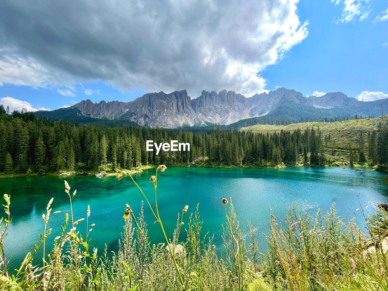 Scenic view of lake by mountains against sky