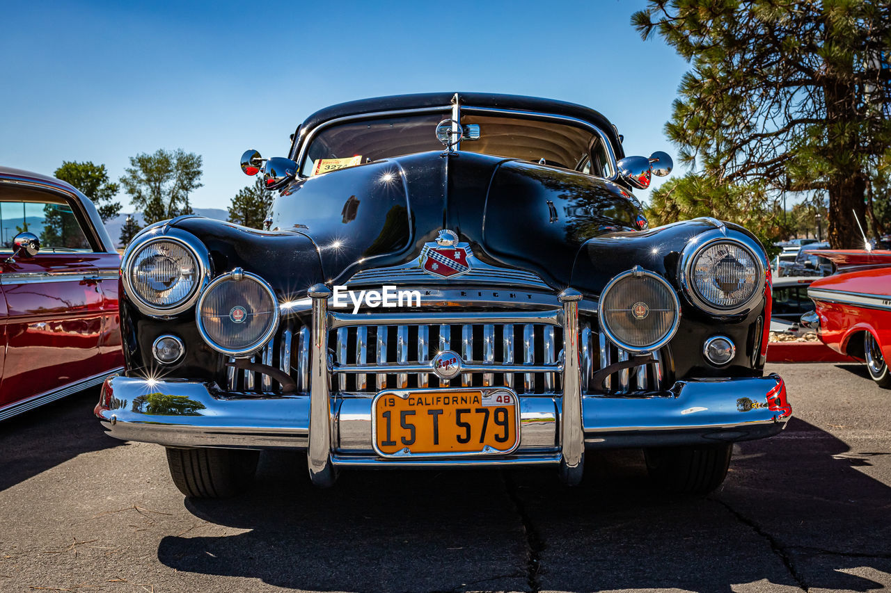car, motor vehicle, vehicle, mode of transportation, transportation, land vehicle, antique car, vintage car, automobile, luxury vehicle, retro styled, blue, sky, nature, day, clear sky, the past, history, headlight, outdoors, no people, tree, metal