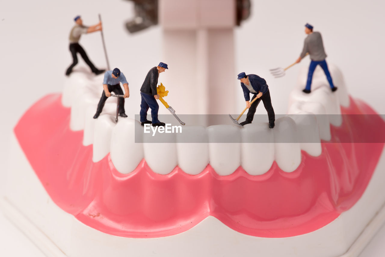 Miniature men working on dentures