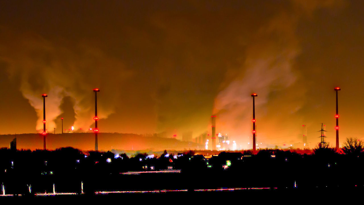 Silhouette industry against sky at night