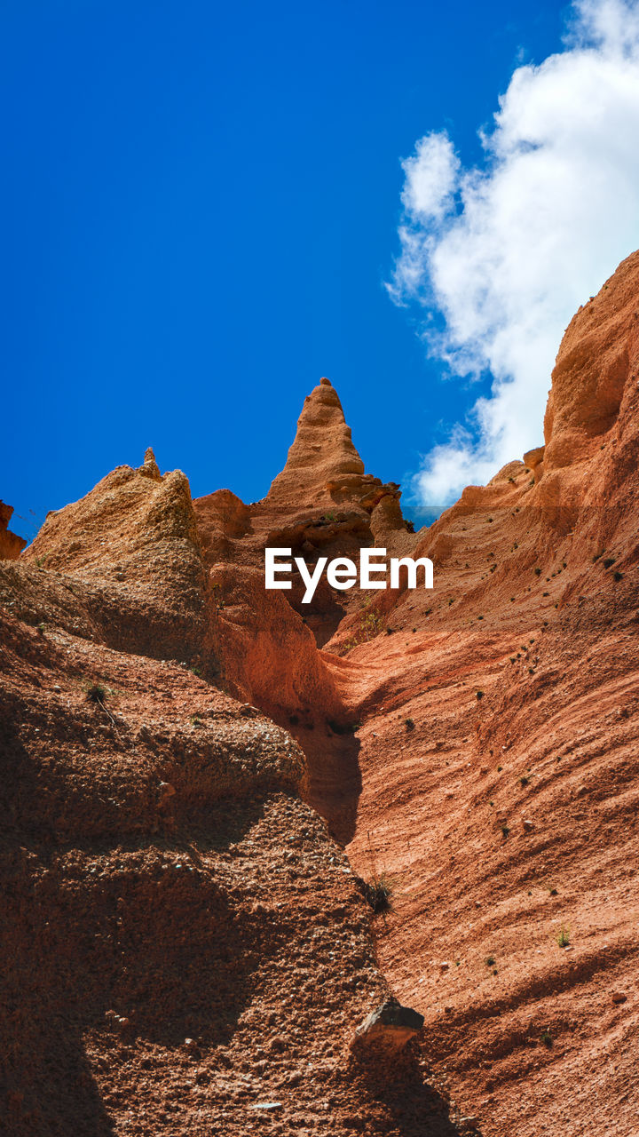 ROCK FORMATIONS ON LANDSCAPE AGAINST BLUE SKY