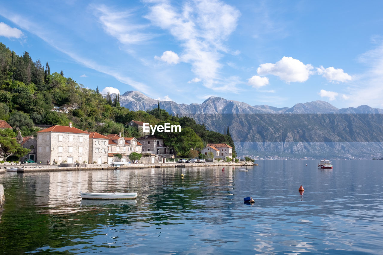 Scenic view of lake and buildings against sky