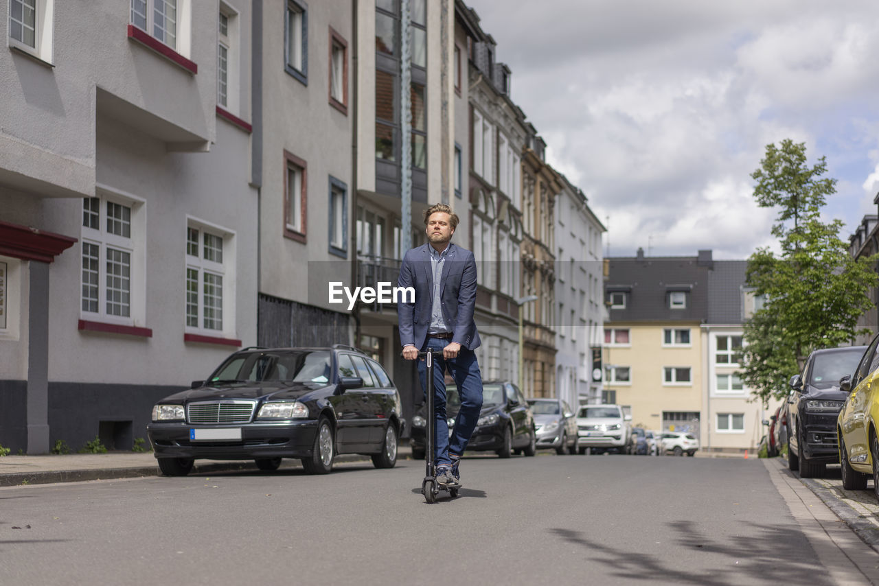 Businessman using e-scooter in the city