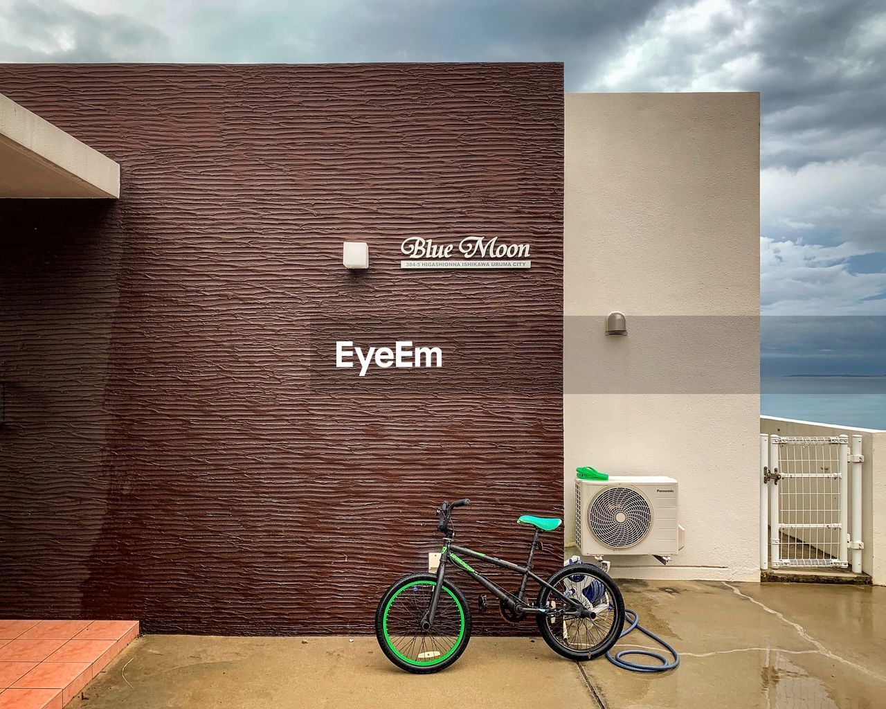 BICYCLE PARKED AGAINST WALL AND BUILDING