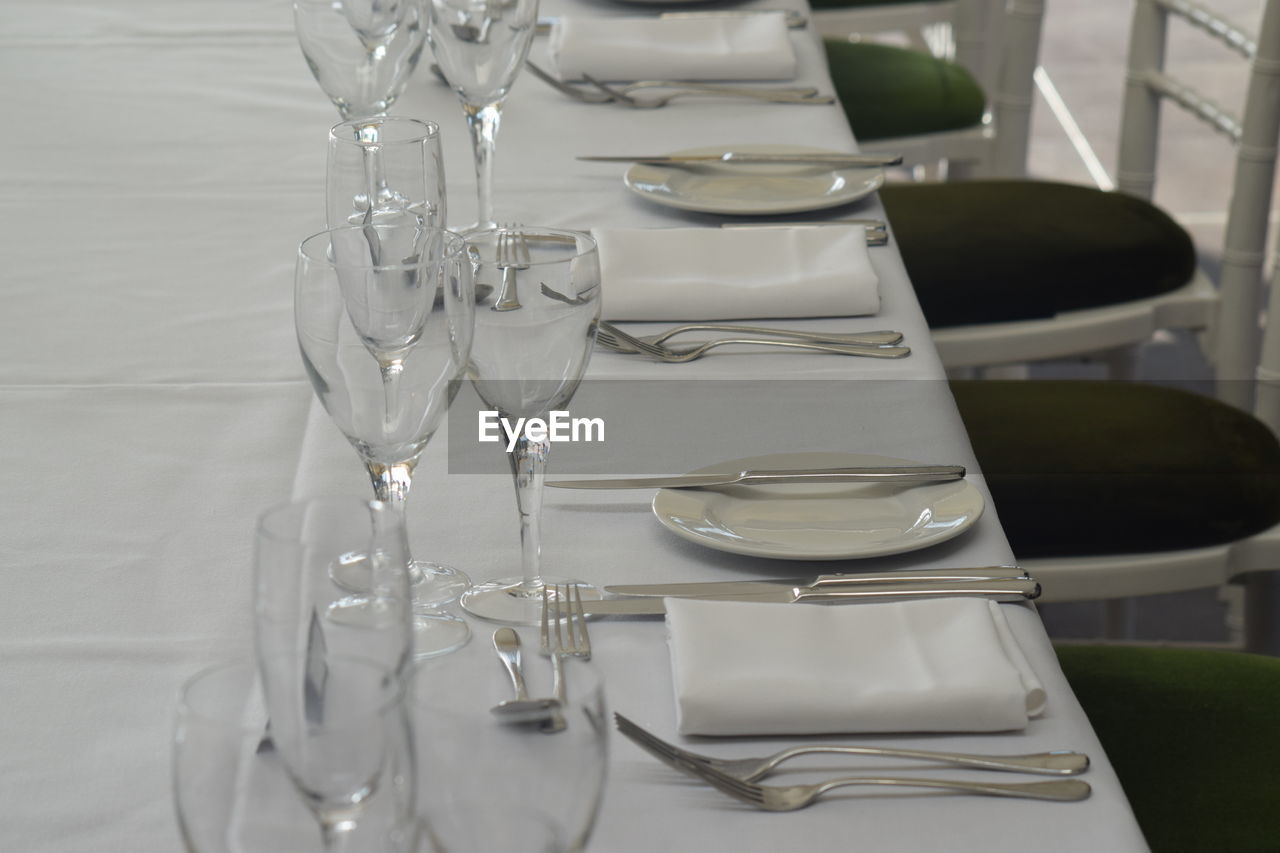 Wineglasses with plates and forks arranged on table