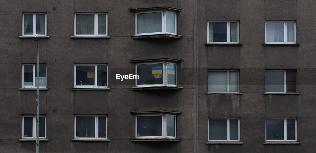 Ukrainian flag on residential building window.