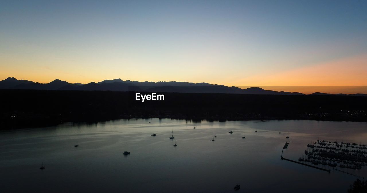 Scenic view of lake against clear sky during sunset