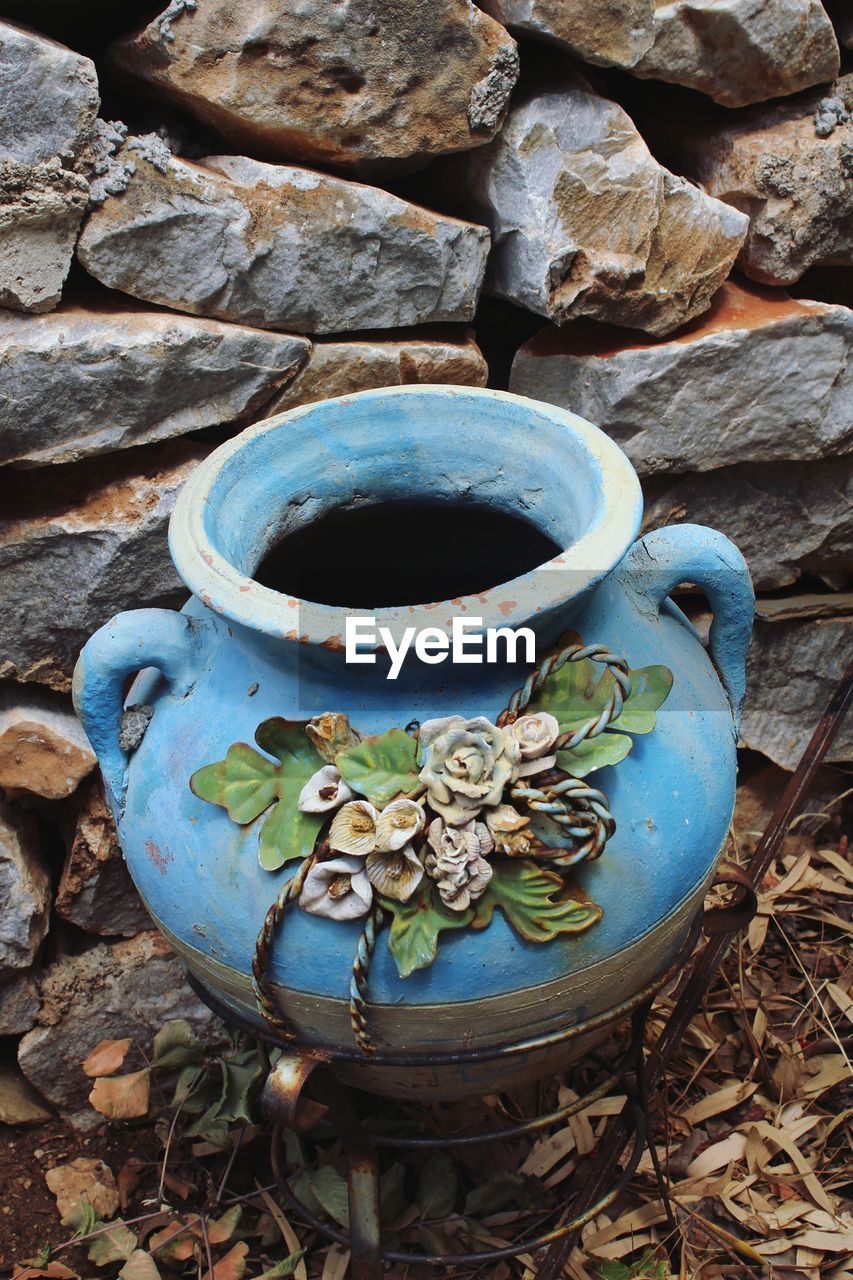 HIGH ANGLE VIEW OF COFFEE CUPS ON ROCK