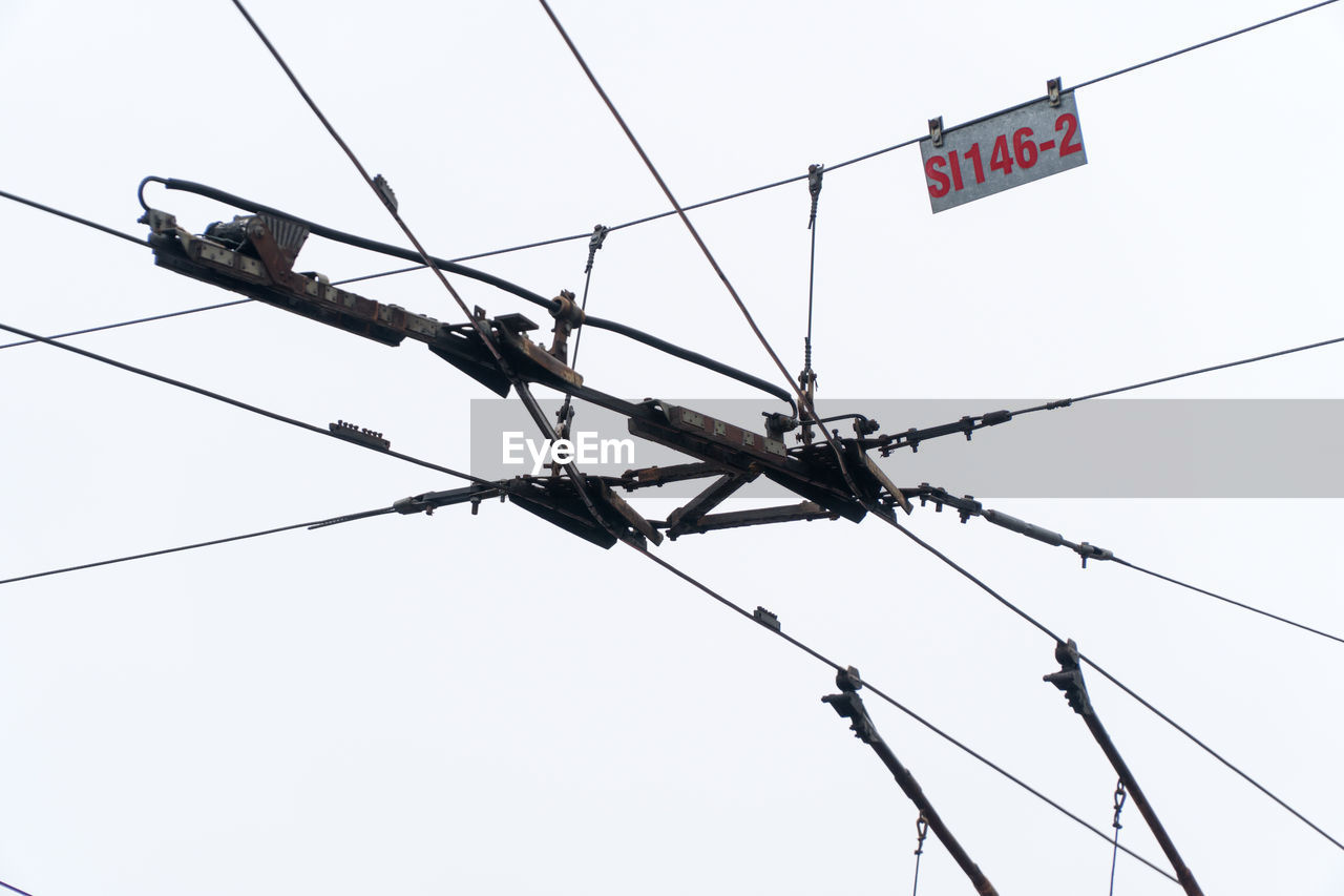 LOW ANGLE VIEW OF POWER LINES AGAINST CLEAR SKY