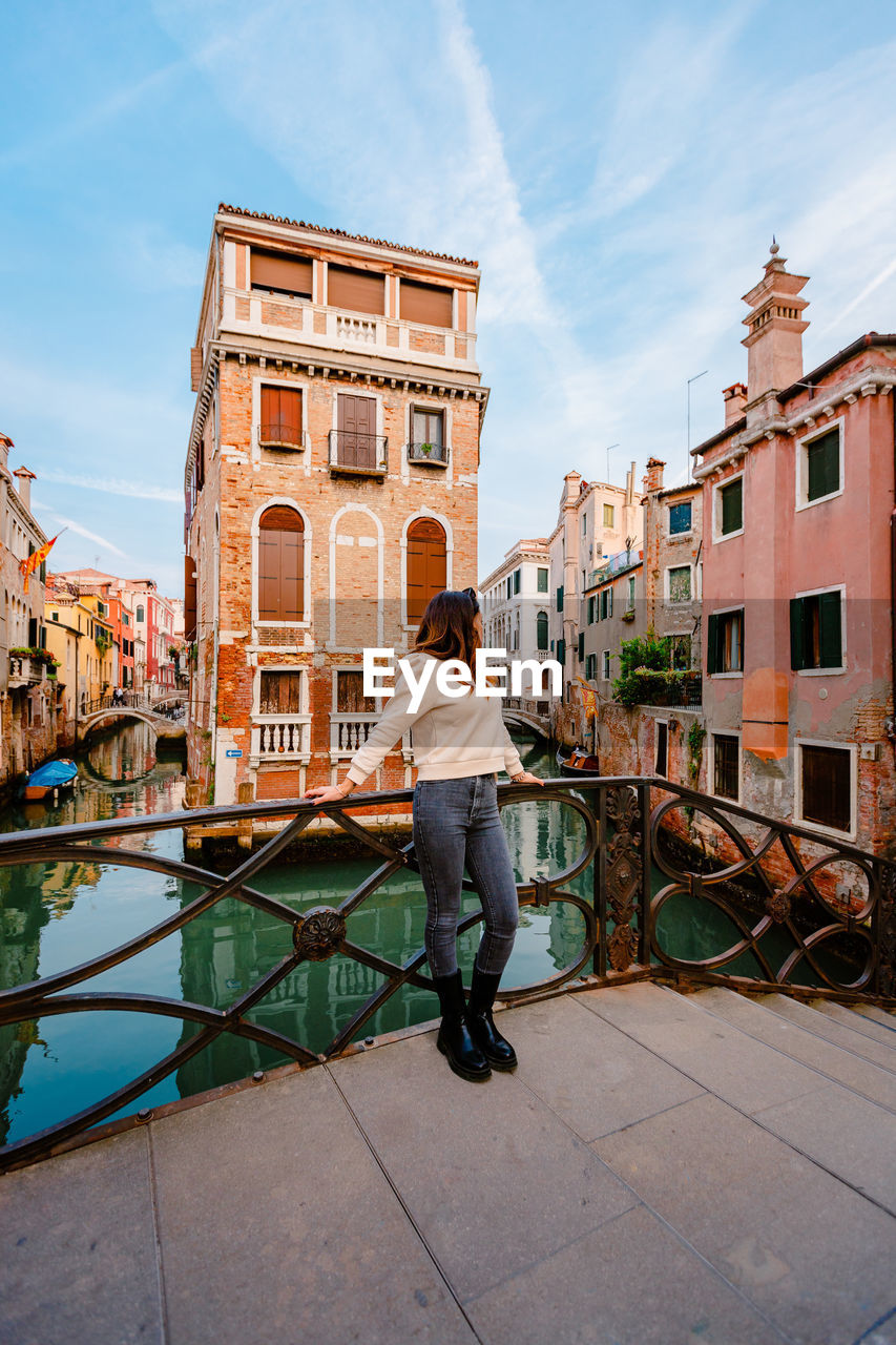 Woman on bridge with characteristic venetian building behind her
