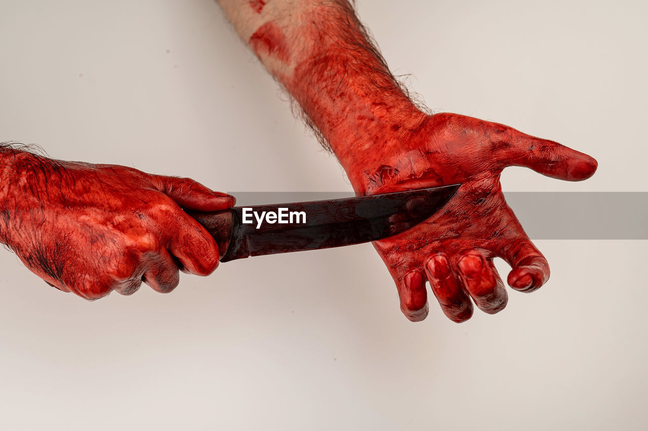 cropped hand of person holding rusty metal against white background