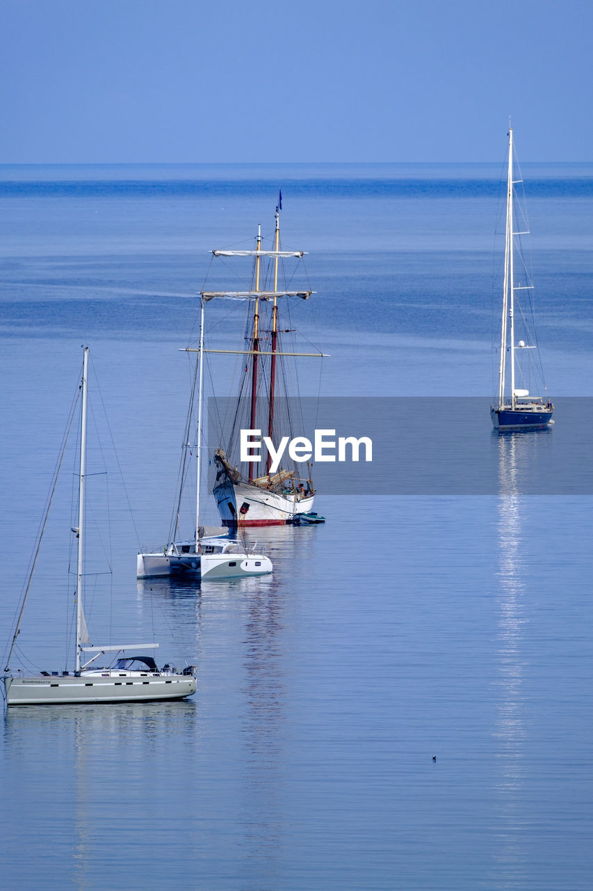 Sailboat sailing on sea against blue sky