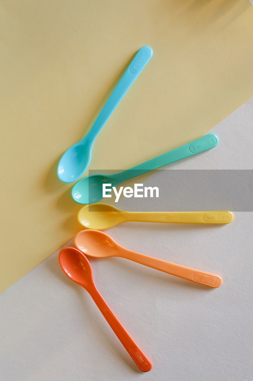 High angle view of chopsticks over yellow background