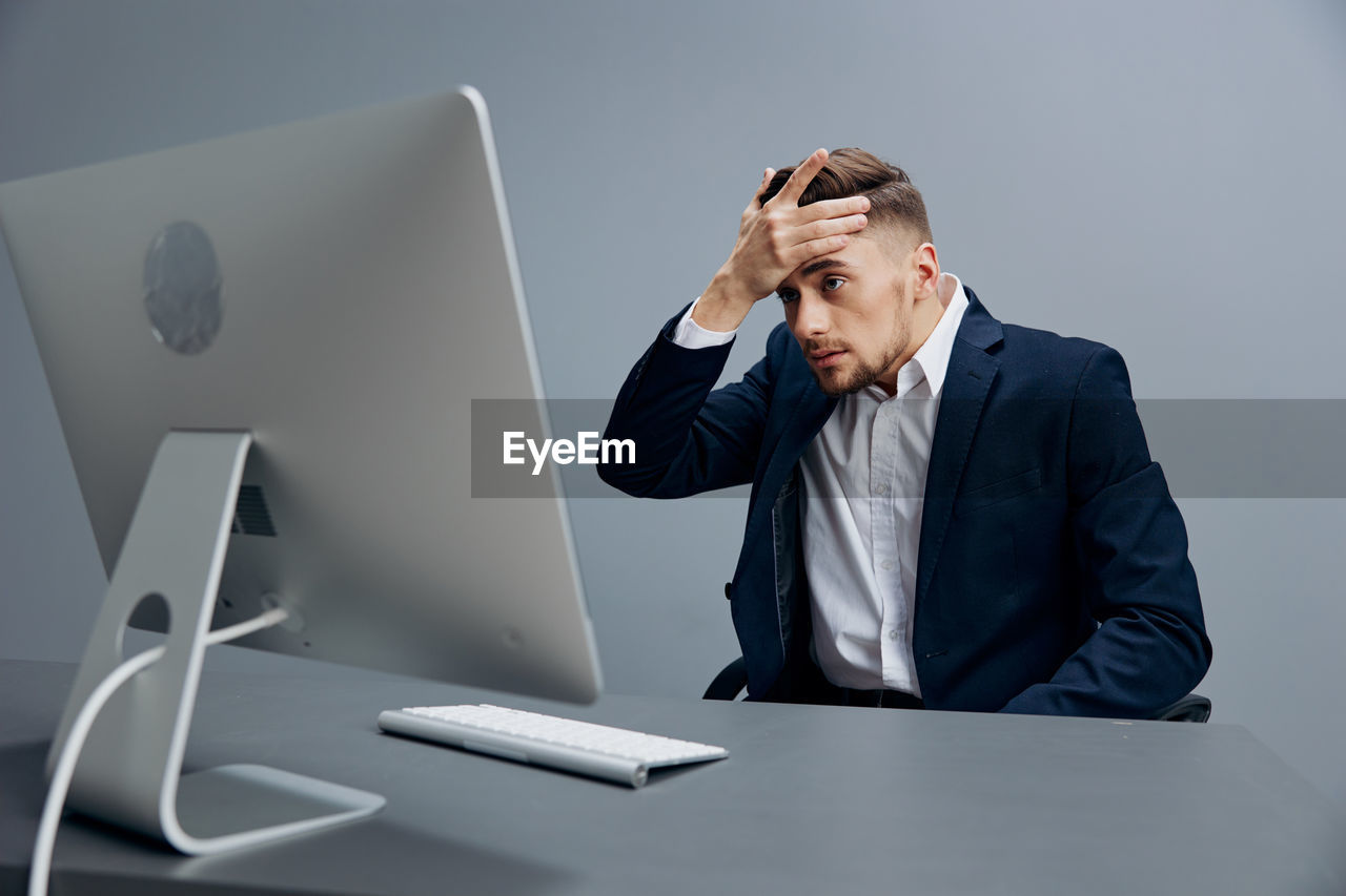 side view of young man using laptop at desk