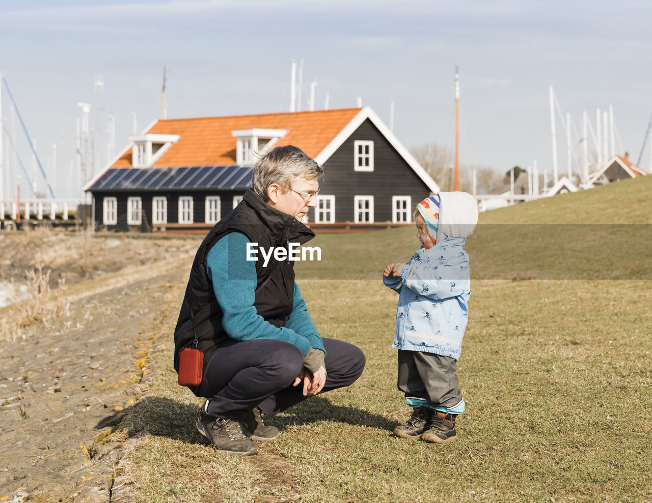 Full length of grandfather and granddaughter on field