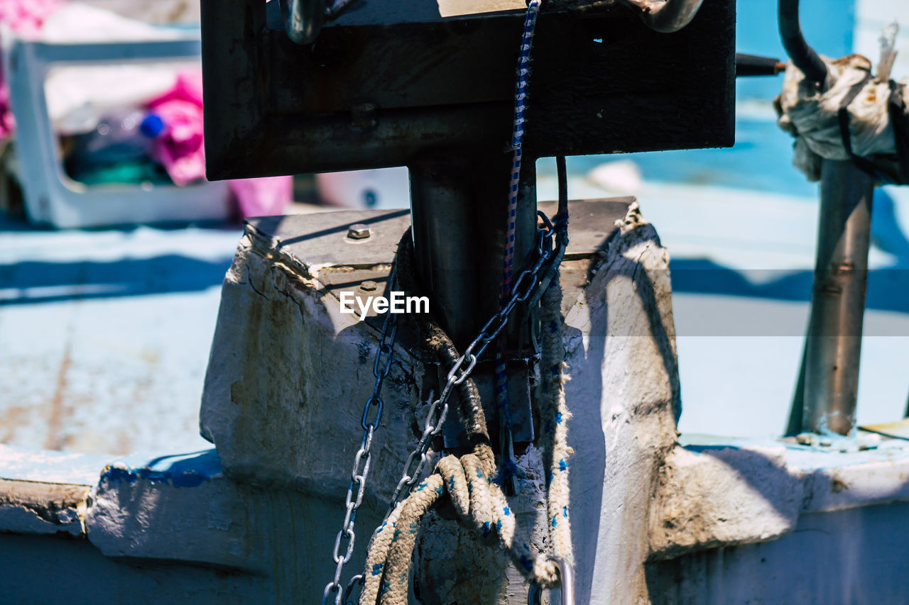 CLOSE-UP OF ROPE TIED UP ON METAL BOAT