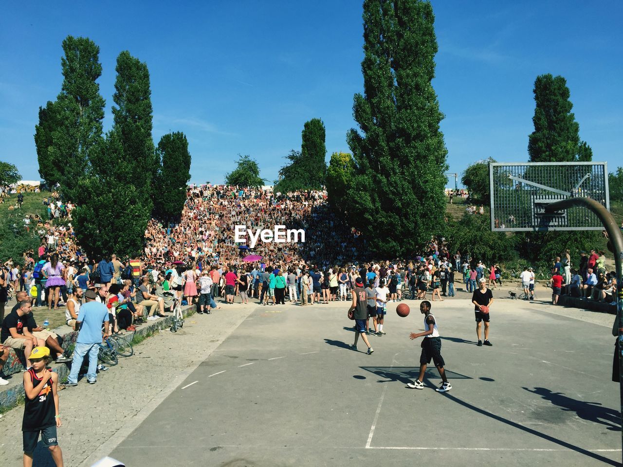 Crowd relaxing while looking at basketball players in mauerpark