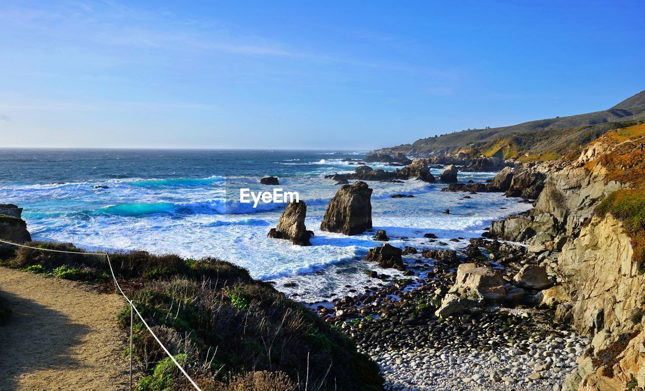 Scenic view angry sea against rocky shore