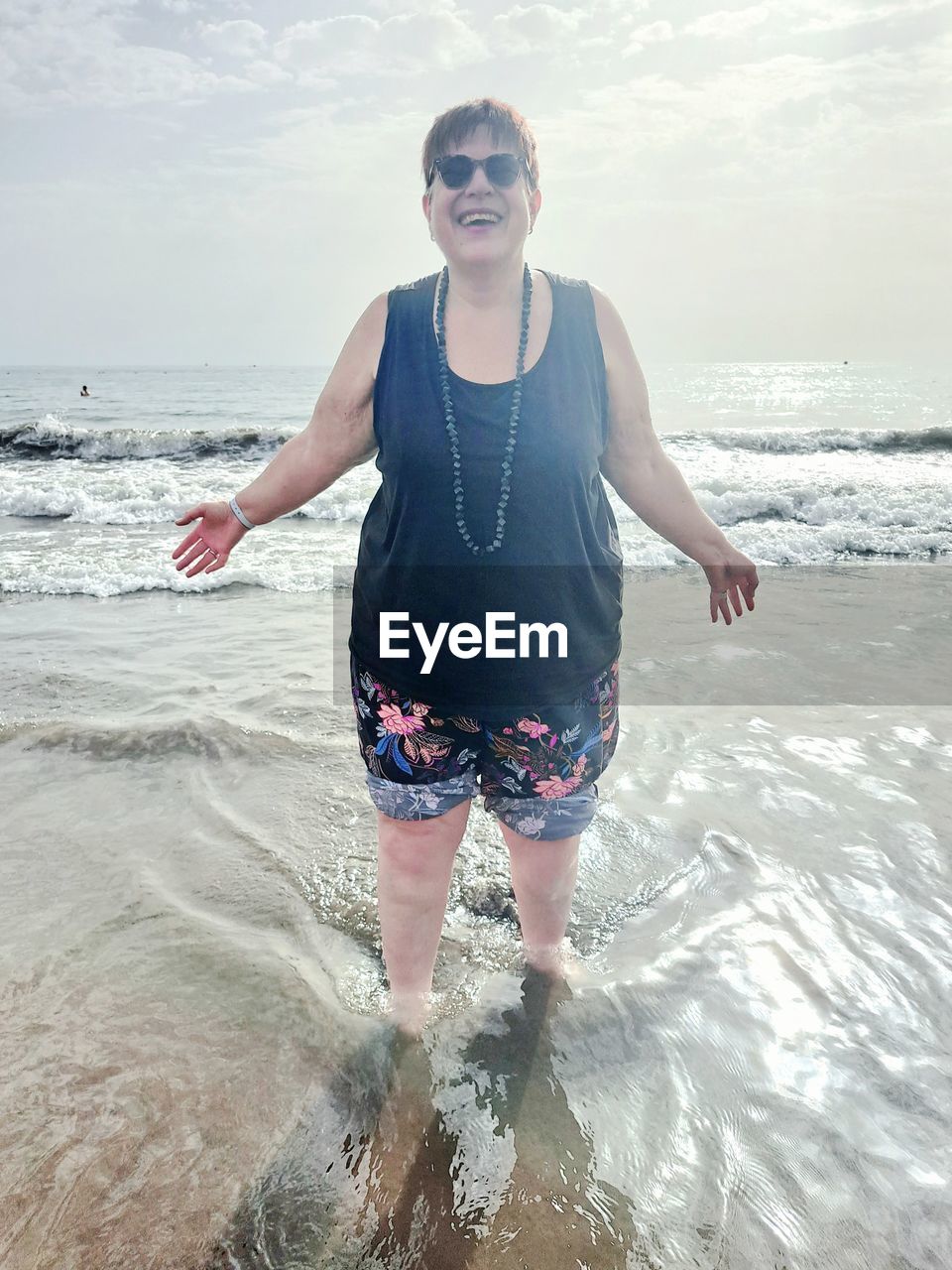 water, sea, one person, beach, land, front view, nature, sky, leisure activity, adult, holiday, ocean, vacation, trip, motion, wave, lifestyles, day, sand, young adult, standing, clothing, three quarter length, sports, portrait, horizon over water, outdoors, sunlight, casual clothing, summer, beauty in nature, women, full length, swimming, water sports, coast, smiling, horizon, shore, emotion, happiness, looking at camera, person, fashion, glasses, travel, enjoyment, surfing, relaxation, cloud, carefree, sunglasses, vitality