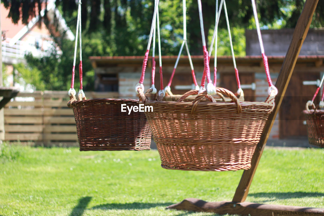 Empty swing hanging in basket on field