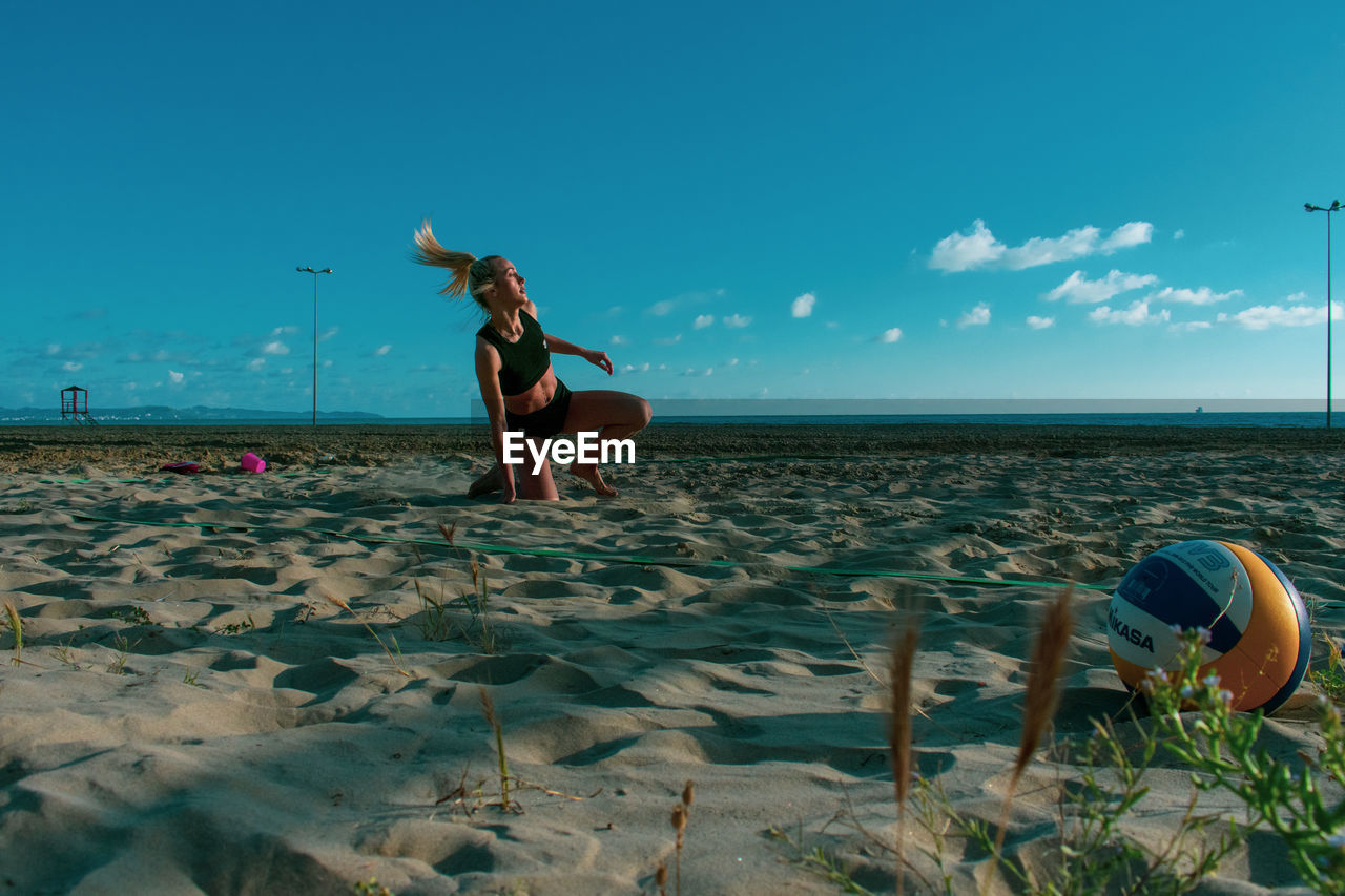 Full length of woman on beach against sky