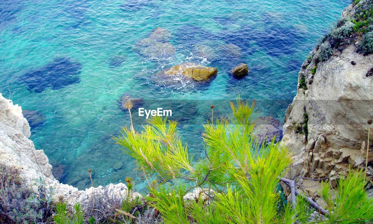 HIGH ANGLE VIEW OF ROCKS ON SEA SHORE