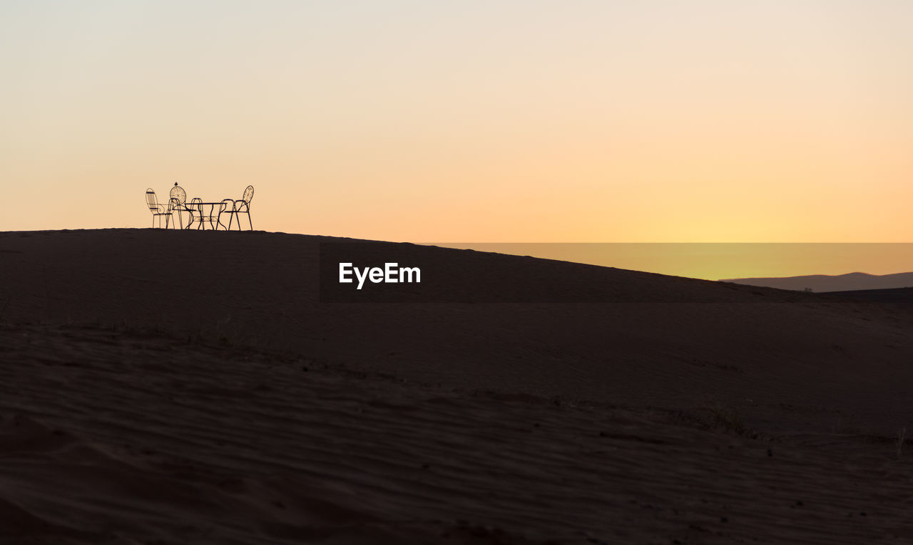 Scenic view of desert against sky during sunset