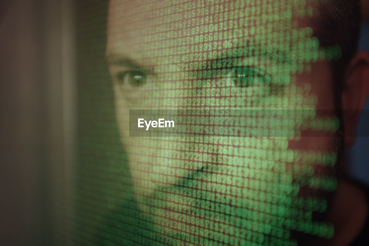 Computer screen with binary code over man's face