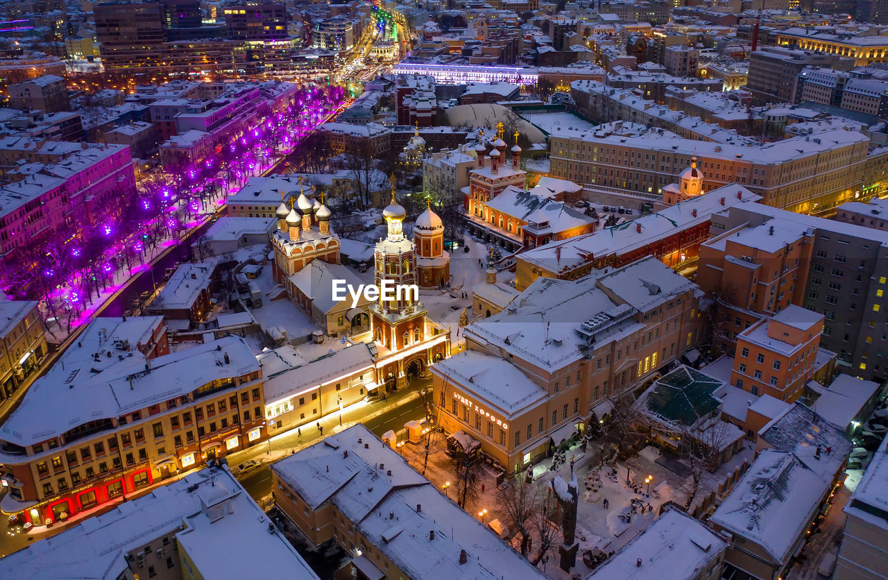 Aerial view of illuminated buildings in city during winter