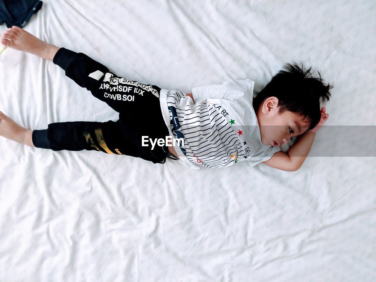 Directly above shot of boy lying on bed