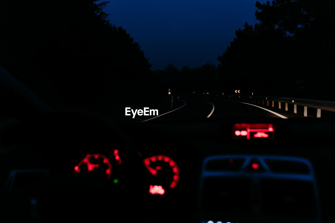 Road seen through car windshield at night