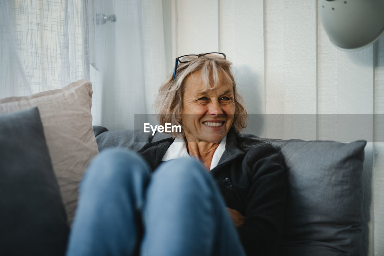 Smiling senior woman sitting on sofa