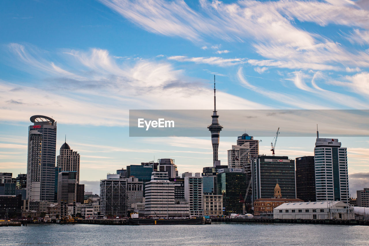 Buildings in city against cloudy sky