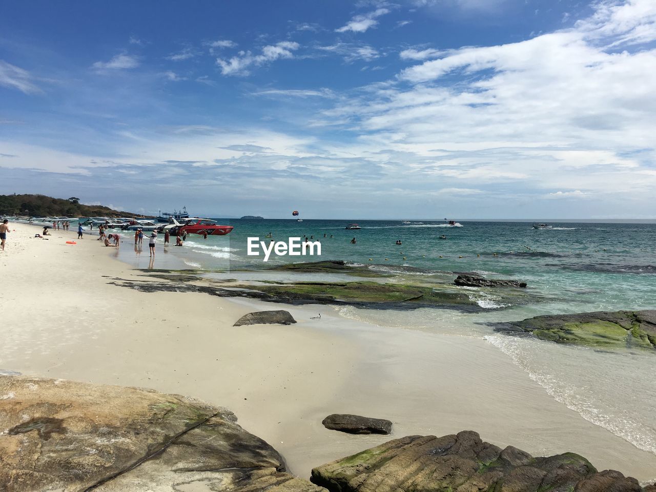 People enjoying at beach against sky