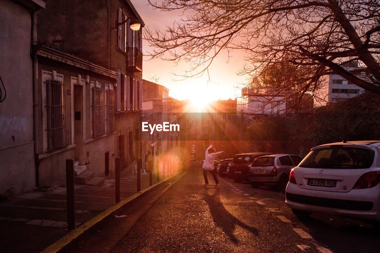 CARS ON ROAD IN CITY AT SUNSET