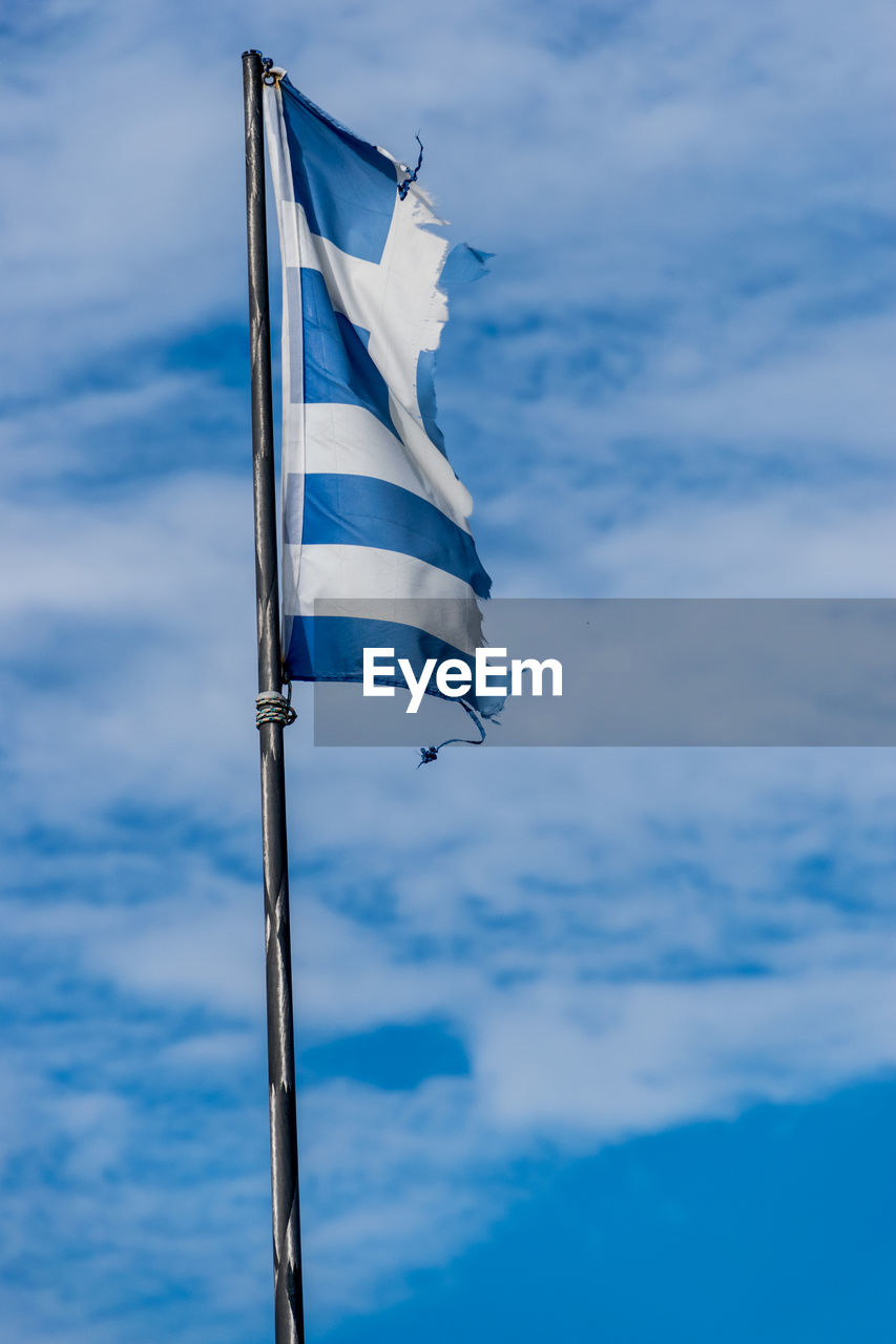 Low angle view of greek flag against blue cloudy sky