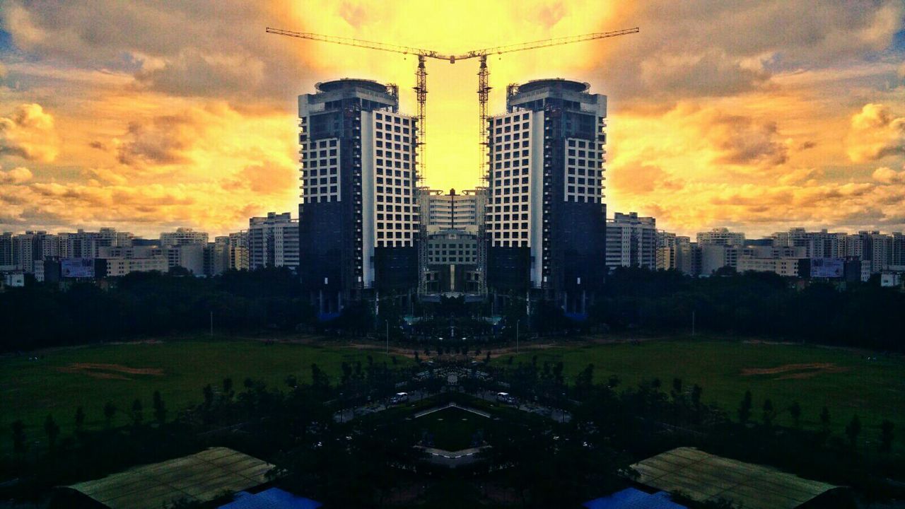 SILHOUETTE OF BUILDINGS AGAINST CLOUDY SKY DURING SUNSET