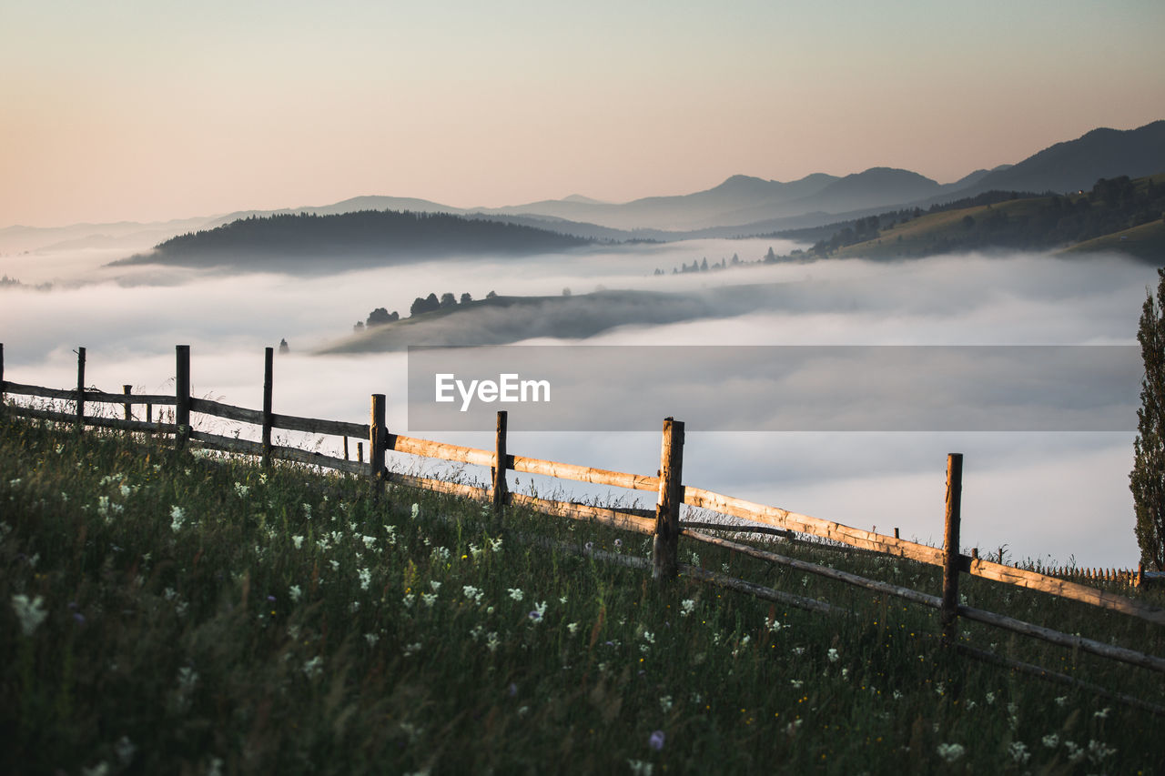 View of wooden railing against cloudscape