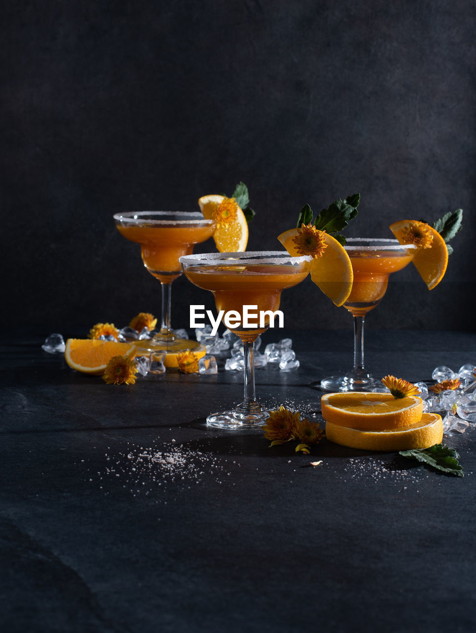 food and drink, food, fruit, alcohol, yellow, drink, cocktail, still life photography, refreshment, studio shot, healthy eating, citrus fruit, glass, no people, alcoholic beverage, black background, martini glass, freshness, cocktail garnish, still life, dark, household equipment, orange color, indoors, drinking glass, martini
