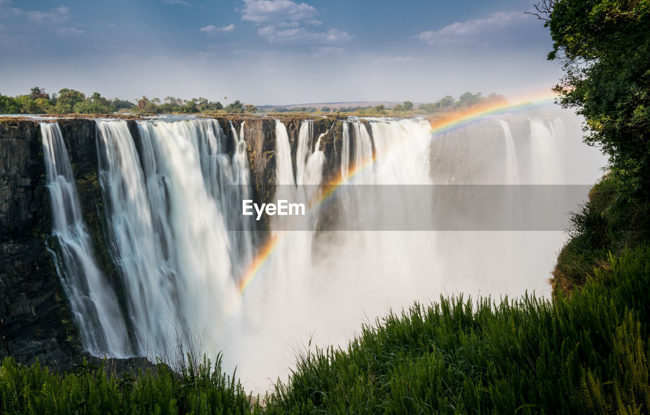 Scenic view of waterfall against sky