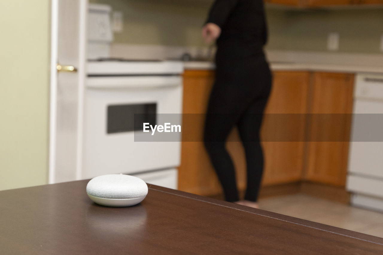 LOW SECTION OF WOMAN STANDING BY BALL ON TABLE