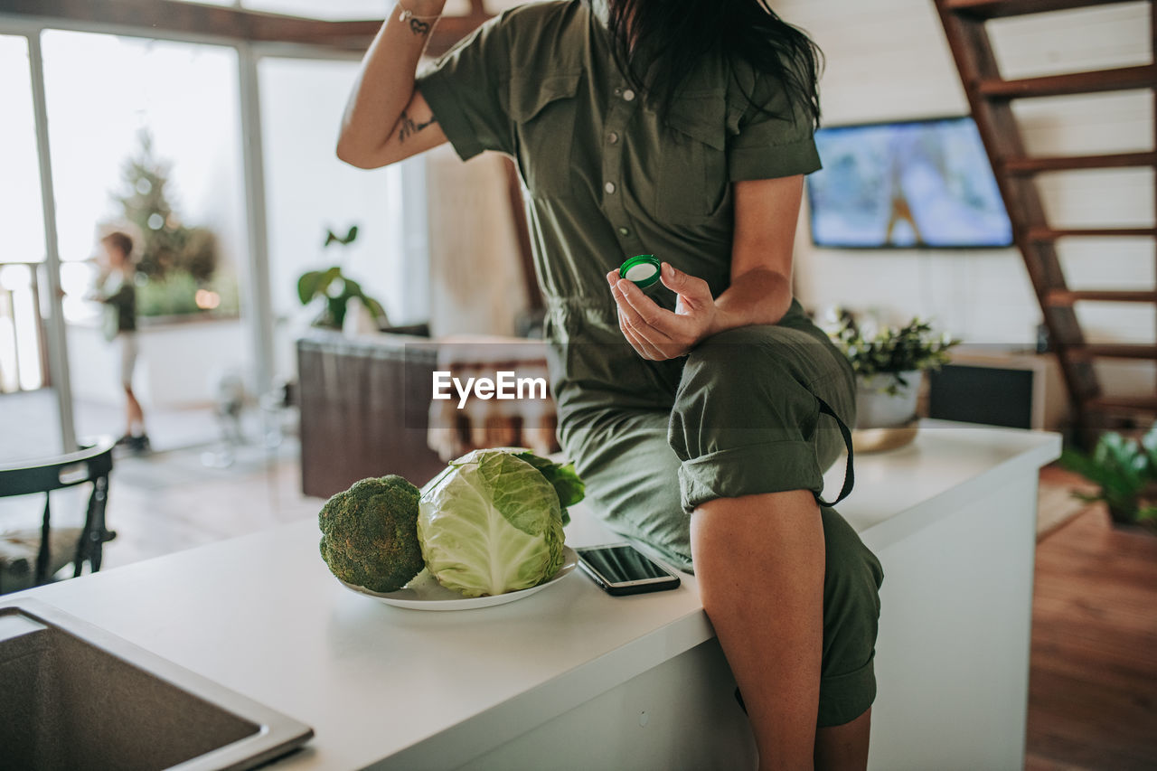 Midsection of woman standing on table