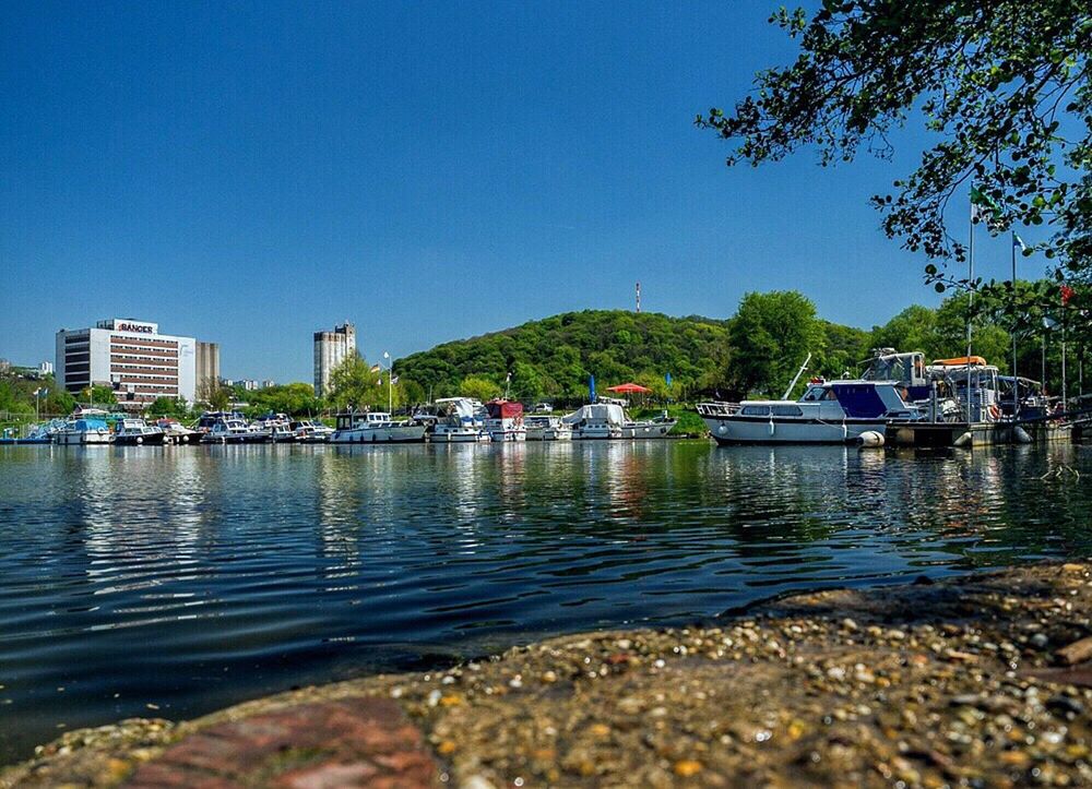 CALM LAKE WITH BUILDINGS IN BACKGROUND