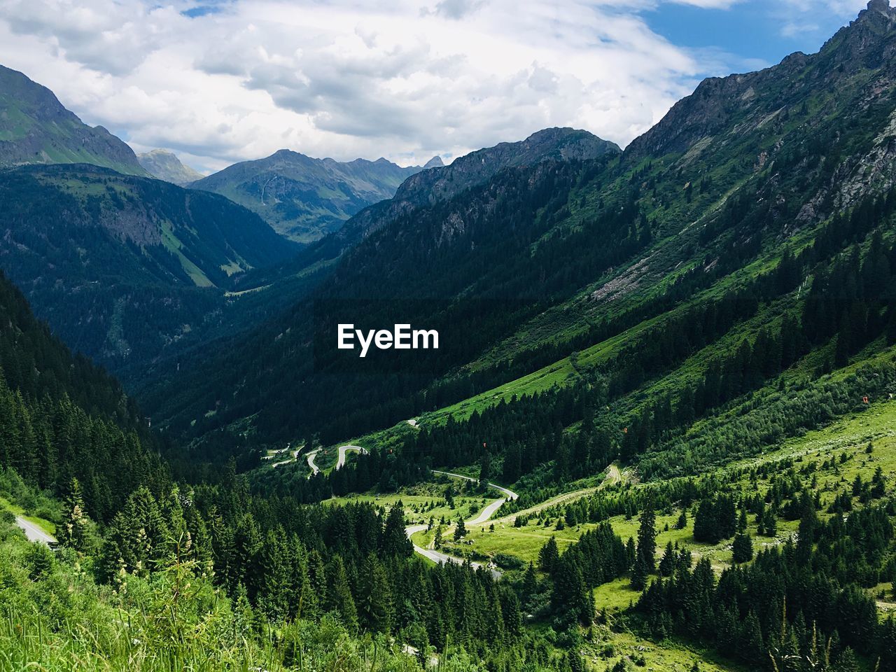 Scenic view of valley and mountains against sky