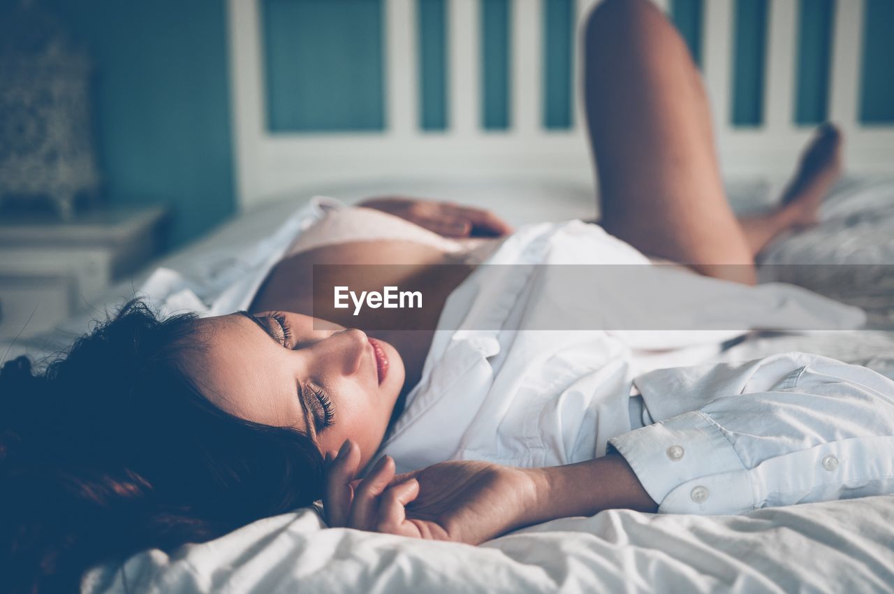Young woman sleeping on bed at home
