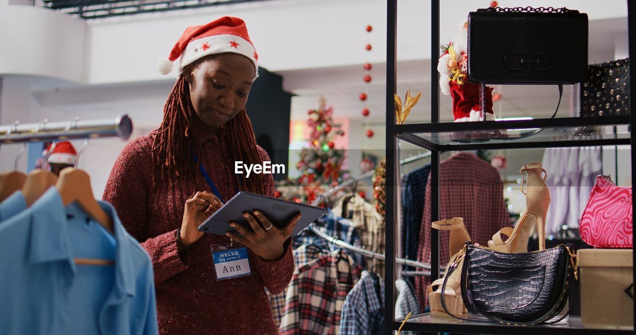 portrait of young woman using mobile phone while standing in store