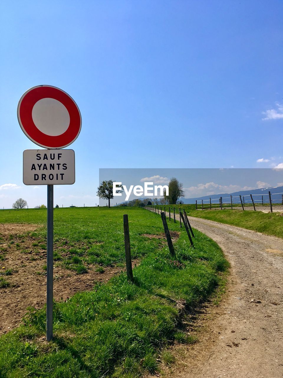 ROAD SIGN ON FIELD AGAINST CLEAR SKY