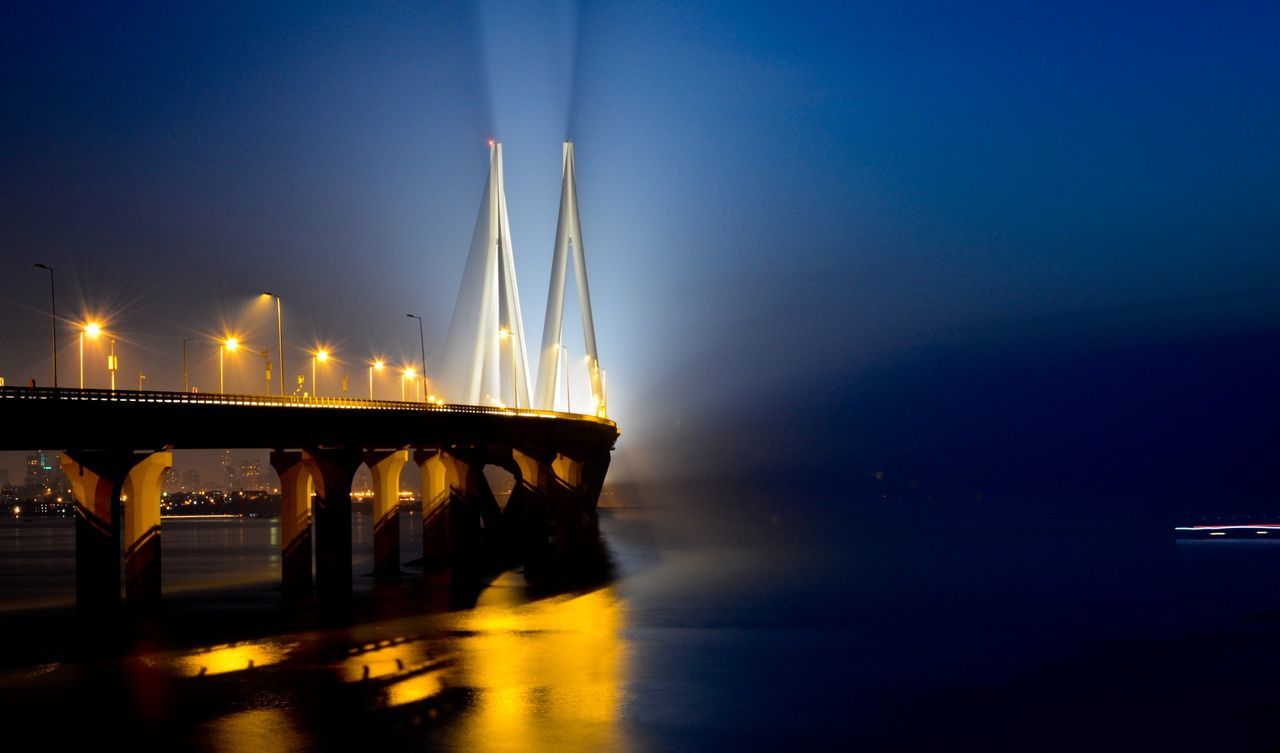 Illuminated bandra–worli sea link over arabian sea against sky at night