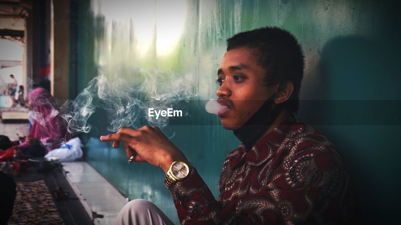 Portrait of young man smoking cigarette